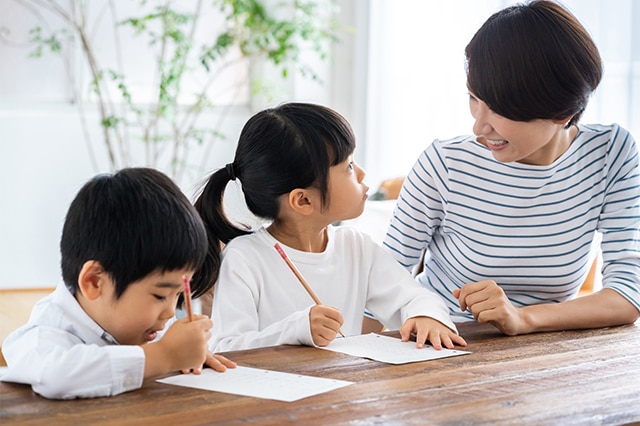 子供が親と一緒にリビングで学習